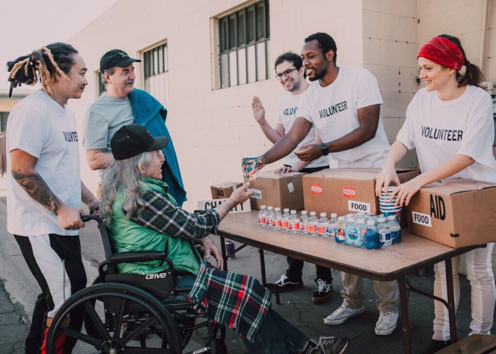 https://www.pexels.com/photo/a-group-of-volunteers-assisting-an-elderly-person-on-a-black-wheelchair-for-charity-6646917/