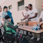 https://www.pexels.com/photo/a-group-of-volunteers-assisting-an-elderly-person-on-a-black-wheelchair-for-charity-6646917/