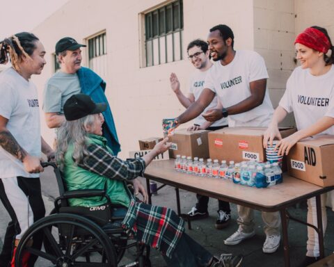https://www.pexels.com/photo/a-group-of-volunteers-assisting-an-elderly-person-on-a-black-wheelchair-for-charity-6646917/